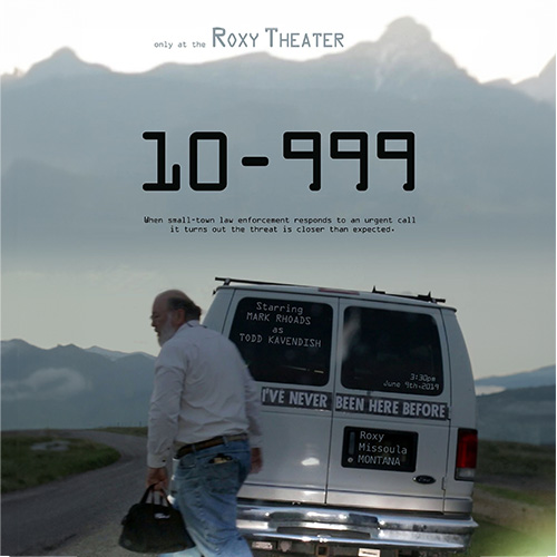 Bolding, bearded older gentleman with black bag is walking towards the left side of the Van with bumber sticker I've never been here before. above in the distance are Montana mountains